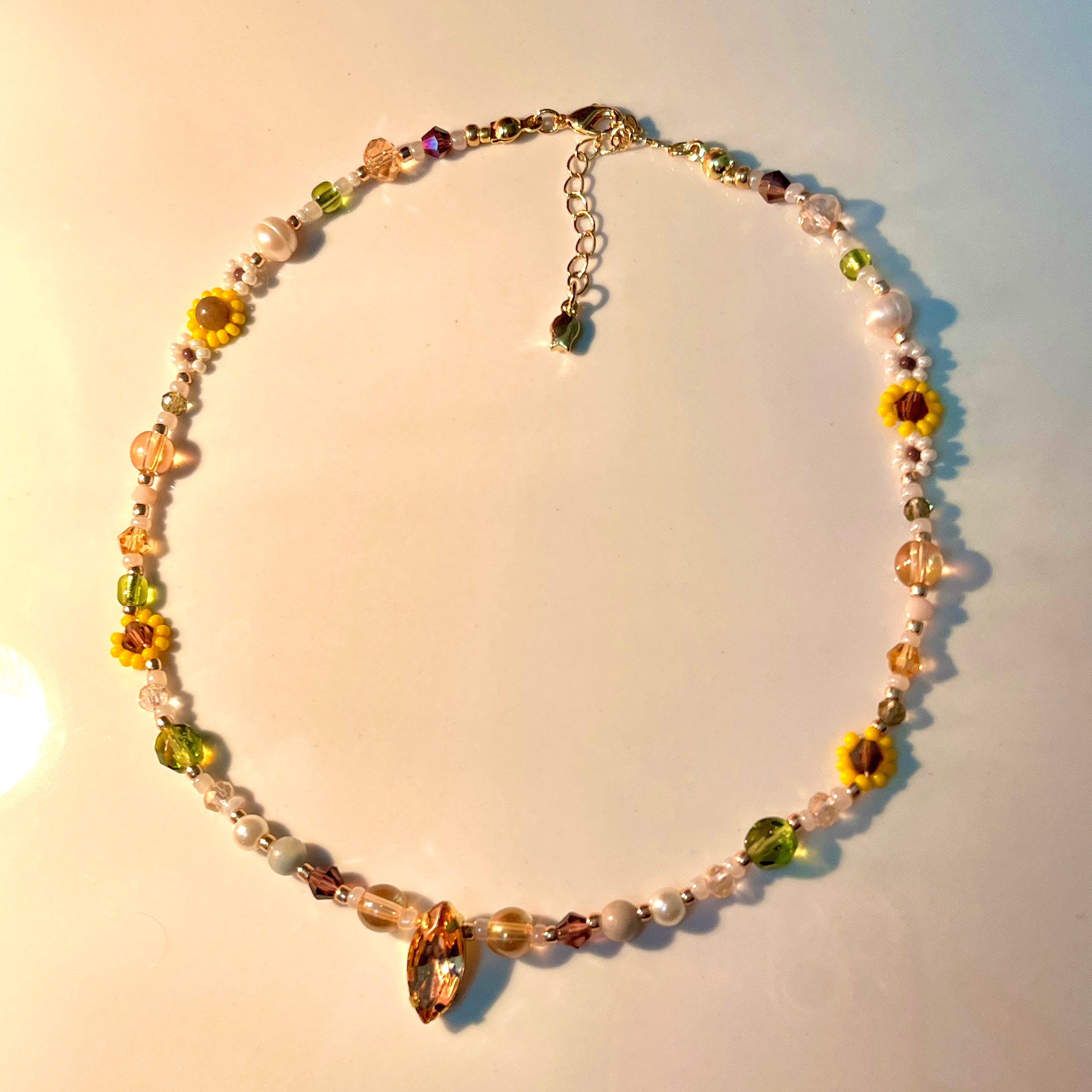 Necklace with floral and bead design on a light background