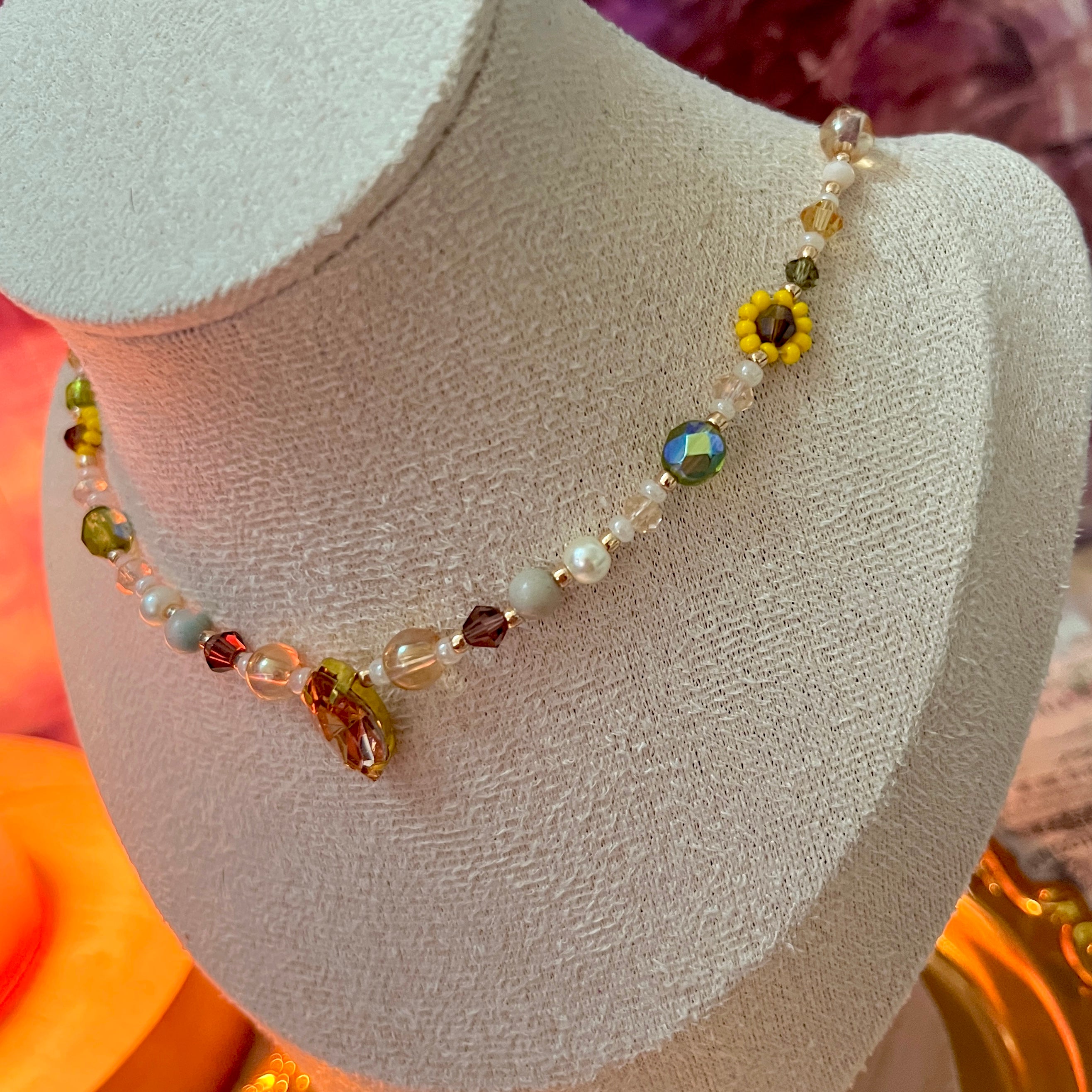 Colorful beaded necklace on a mannequin bust with a blurred background